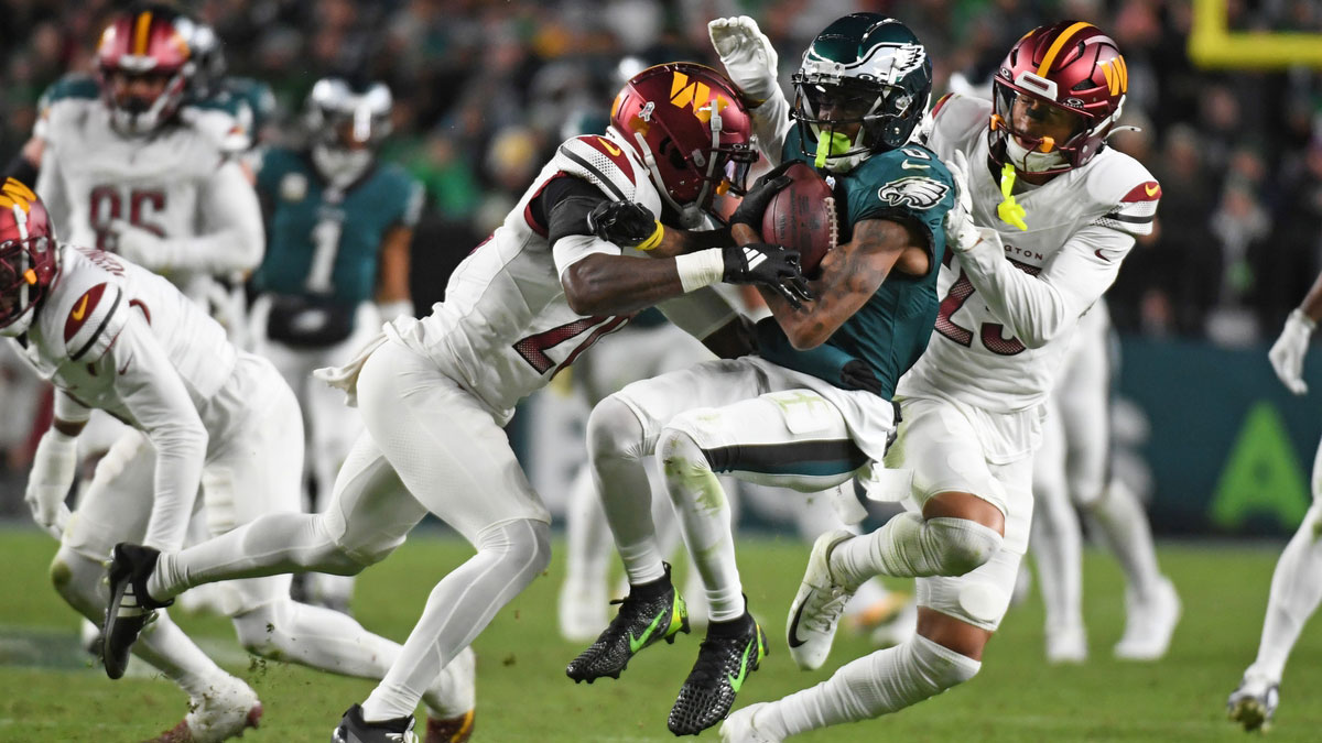 Philadelphia Eagles wide receiver DeVonta Smith (6) is tackled by Washington Commanders safety Quan Martin (20) and cornerback Benjamin St-Juste (25) during the second quarter at Lincoln Financial Field.