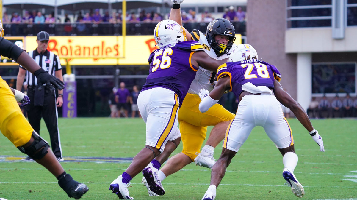 East Carolina Pirates defensive lineman D'Anta Johnson (56) and defensive back Shavon Revel Jr. (28) stops the run by Appalachian State Mountaineers running back Anderson Castle (1) during the first half at Dowdy-Ficklen Stadium