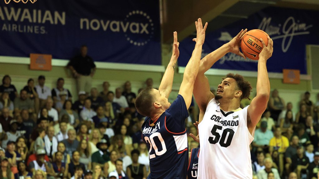 Colorado Buffaloes center Elijah Malone (50) goes for the net as Connecticut Huskies guard Aidan Mahaney (20) guards him during the first half of an NCAA college basketball game at Lahaina Civic Center.