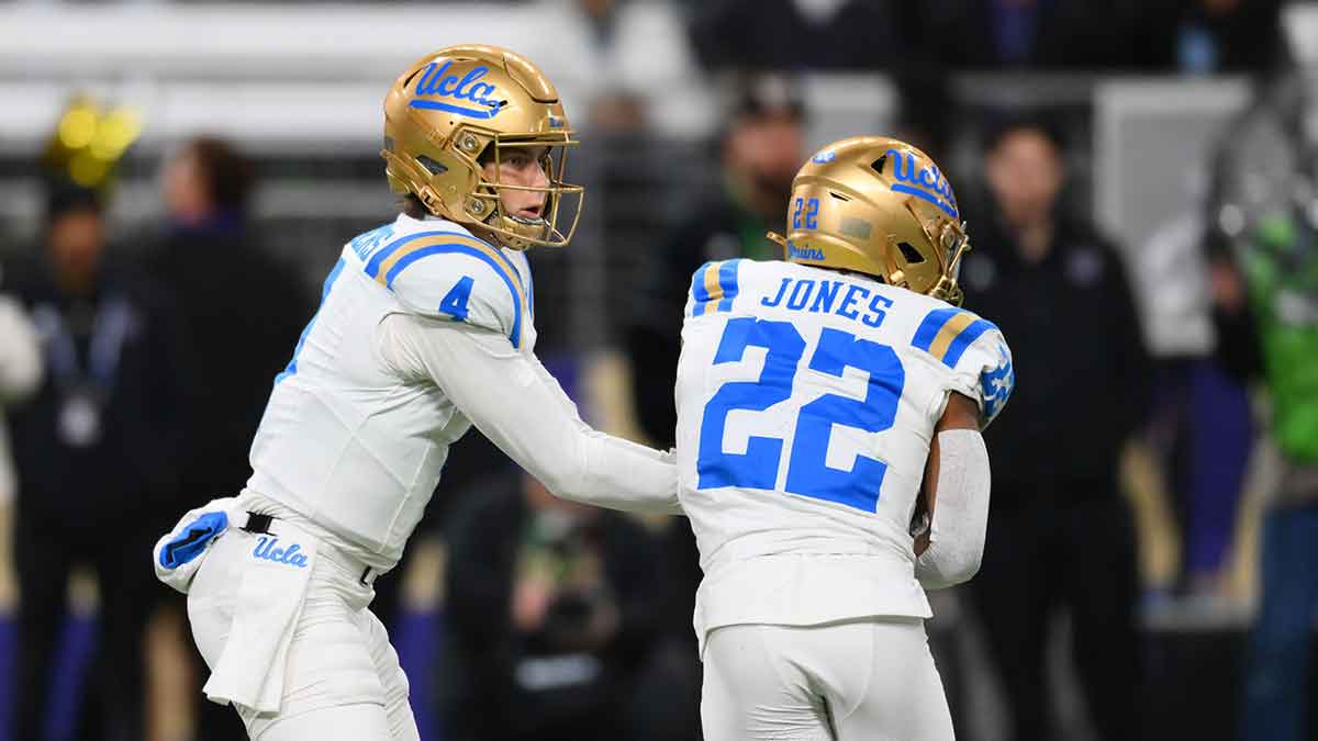 UCLA Bruins quarterback Ethan Garbers (4) hands the ball off to running back Keegan Jones (22) during the first half against the Washington Huskies at Alaska Airlines Field at Husky Stadium.