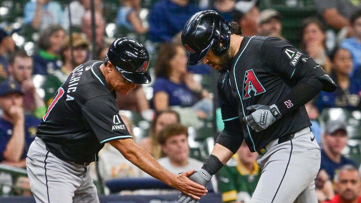 Arizona Diamondbacks third baseman Eugenio Suarez (28) greets third base coach Tony Perezchica after hitting a solo home run in the third inning against the Milwaukee Brewers at American Family Field.