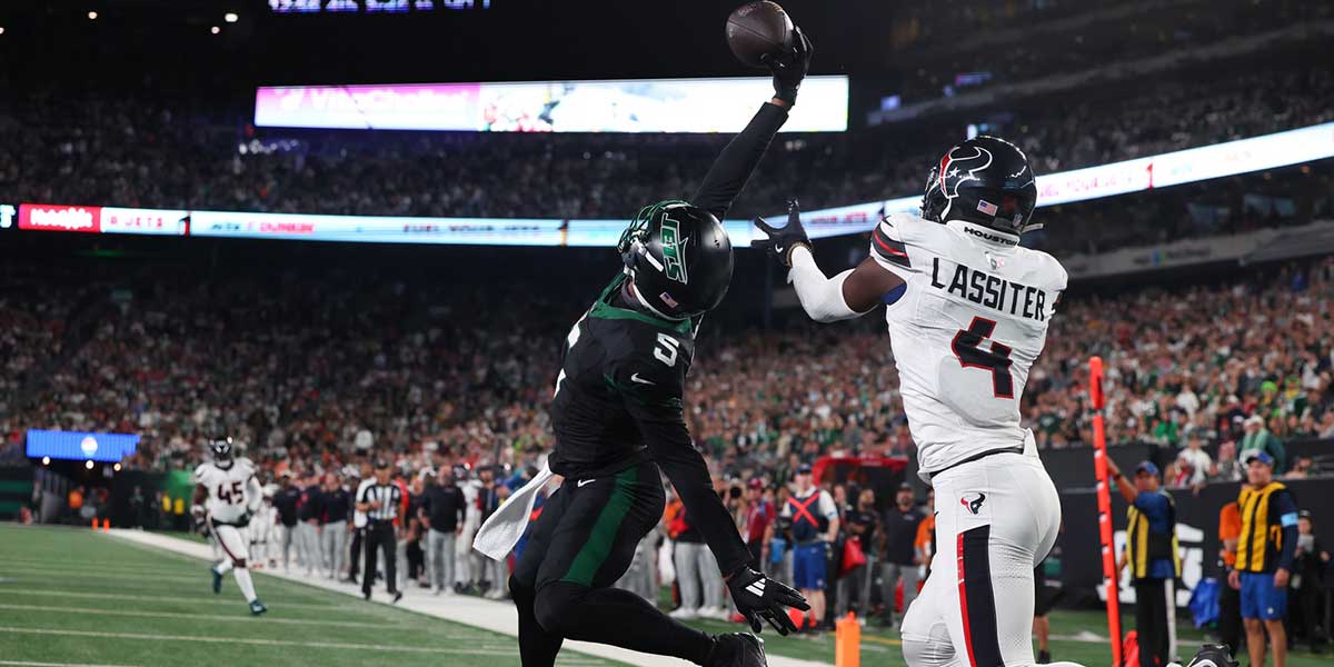 New Jersey, USA; New York Jets wide receiver Garrett Wilson (5) catches a touchdown pass while being defended by Houston Texans cornerback Kamari Lassiter (4) during the second half at MetLife Stadium.