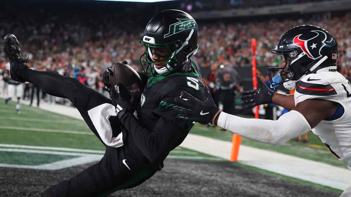 New York Jets wide receiver Garrett Wilson (5) catches a touchdown pass while being defended by Houston Texans cornerback Kamari Lassiter (4) during the second half at MetLife Stadium.