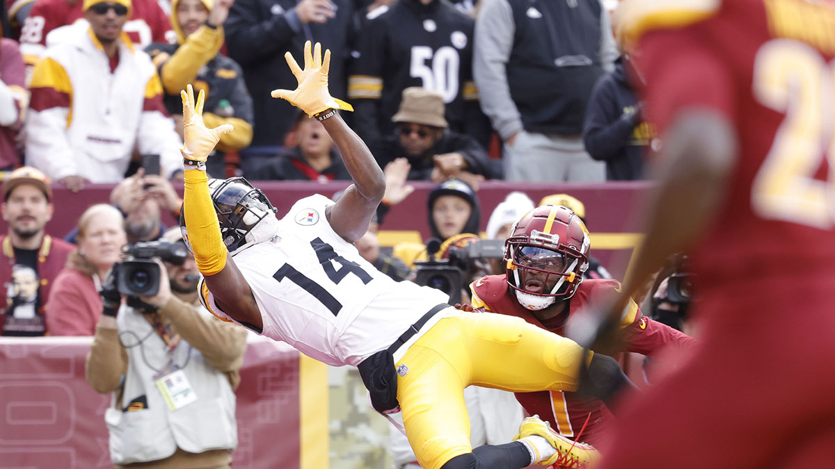 Nov 10, 2024; Landover, Maryland, USA; Pittsburgh Steelers wide receiver George Pickens (14) catches a touchdown pass in front of Washington Commanders cornerback Noah Igbinoghene (1) during the first half at Northwest Stadium. 