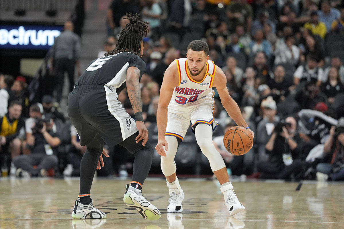 Golden State Warriors guard Stephen Curry (30) dribbles in front of San Antonio Spurs guard Stephon Castle (5) in the first half at Frost Bank Center.