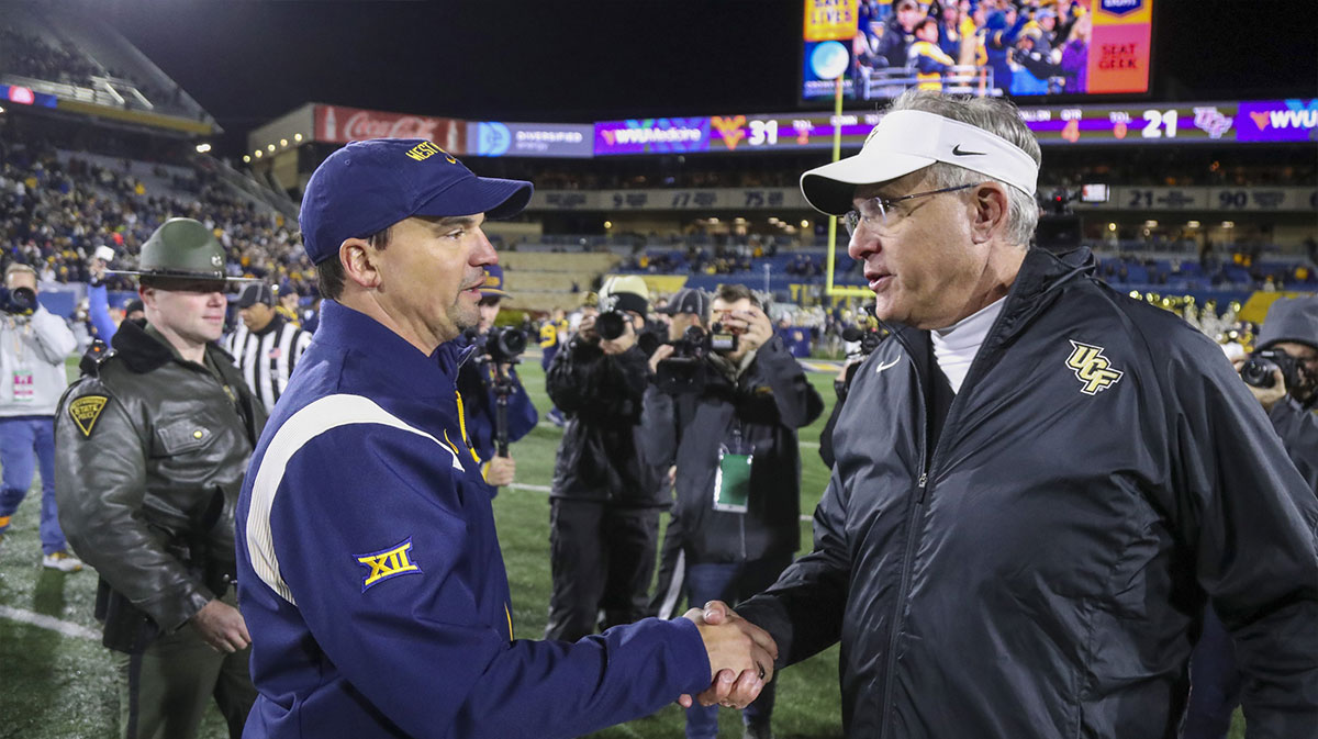 West Virginia Mountaineers head coach Neal Brown (left) talks with UCF Knights head coach Gus Malzahn after a game at Mountaineer Field at Milan Puskar Stadium.