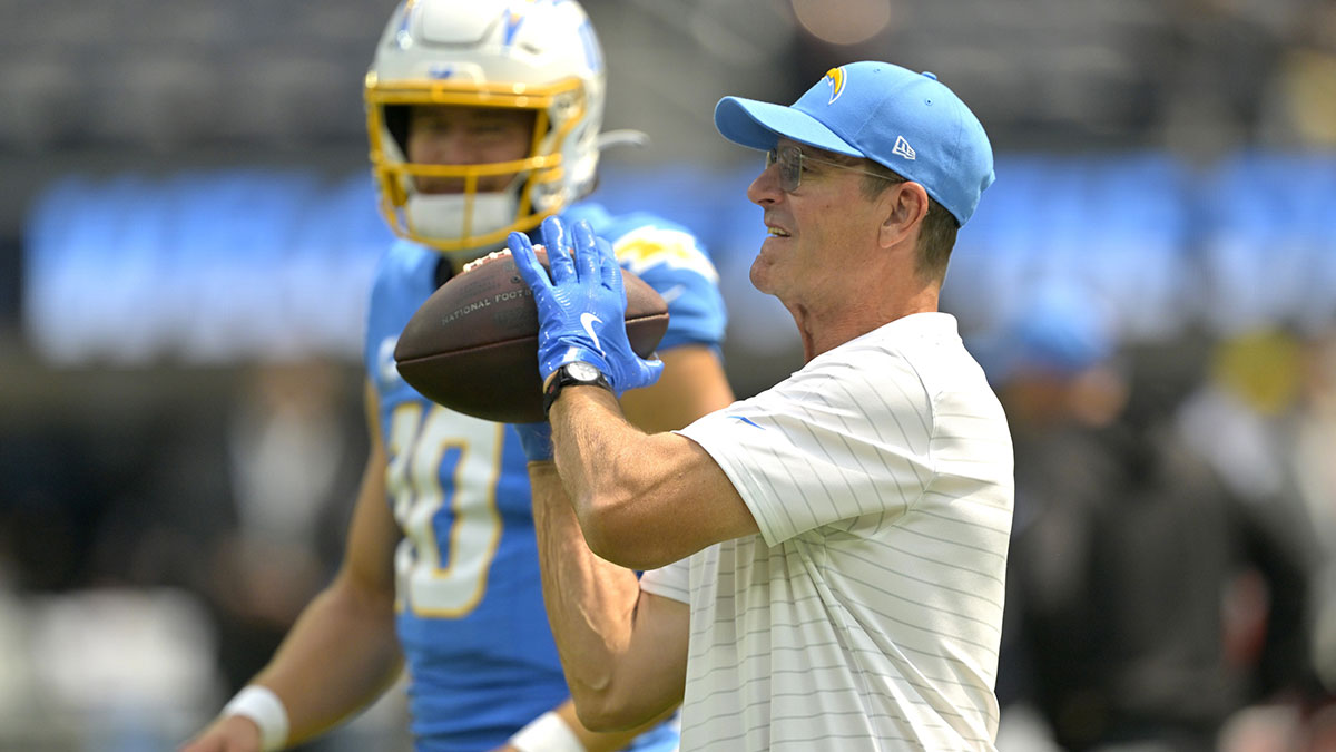 Los Angeles Chargers head coach Jim Harbaugh catches the ball for quarterback Justin Herbert (10) as he warms up prior to the game against the Los Angeles Chargers at SoFi Stadium. 