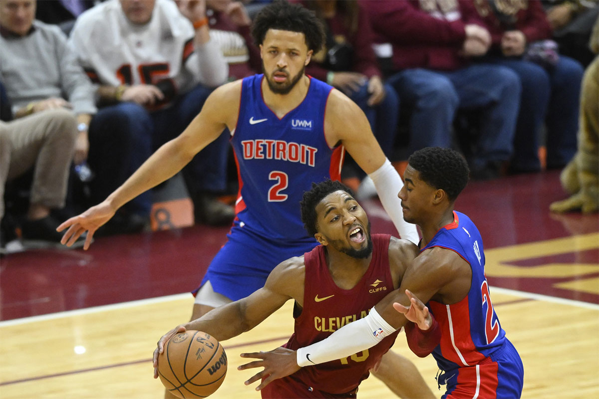 Jan 31, 2024; Cleveland, Ohio, USA; Cleveland Cavaliers guard Donovan Mitchell (45) drives between Detroit Pistons guard Cade Cunningham (2) and guard Jaden Ivey (23) in the fourth quarter at Rocket Mortgage FieldHouse.