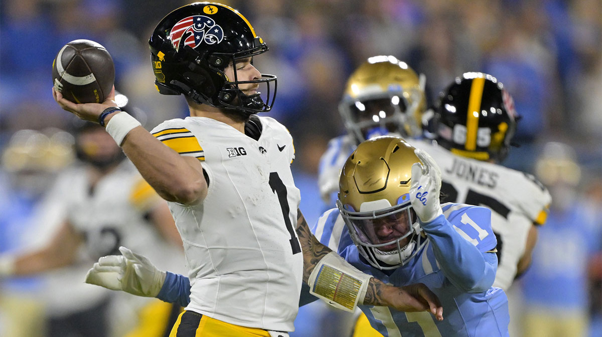 Iowa Hawkeyes quarterback Brendan Sullivan (1) is pressured by UCLA Bruins defensive back Ramon Henderson.