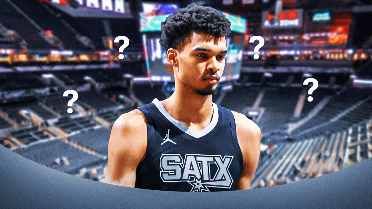 Victor Wembanyama of the Spurs with the Frost Bank Center behind him and with question marks all around him