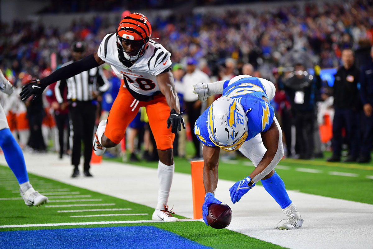 Los Angeles Chargers running back J.K. Dobbins (27) scores a touchdown against Cincinnati Bengals cornerback Josh Newton (28) during the second half at SoFi Stadium. 