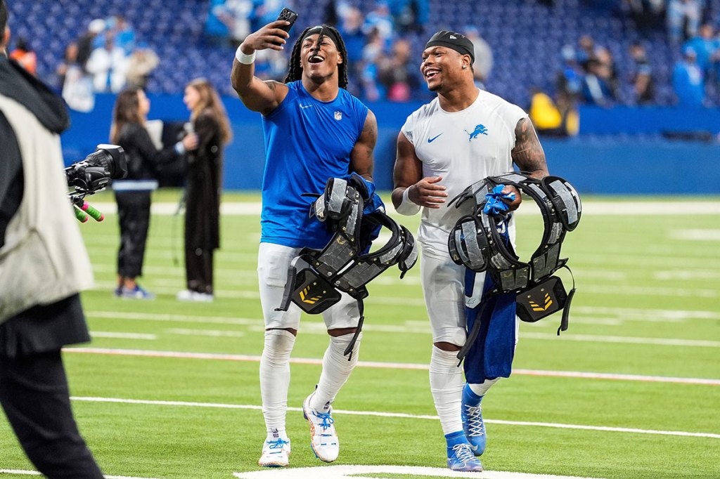 Detroit Lions running backs Jahmyr Gibbs, left, and David Montgomery record a video to celebrate the 24-6 win over the Indianapolis Colts at Lucas Oil Stadium in Indianapolis on Sunday, Nov. 24, 2024.