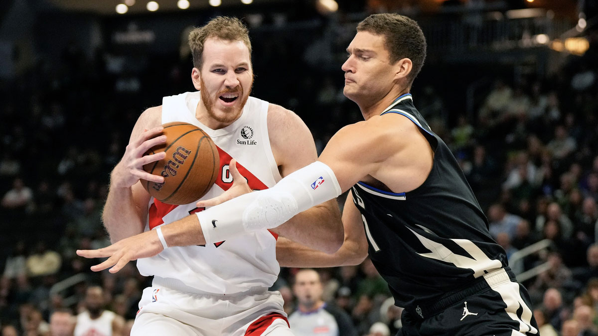 Toronto Raptors center Jakob Poeltl (19) drives for the basket against Milwaukee Bucks center Brook Lopez (11) during the first quarter at Fiserv Forum. 