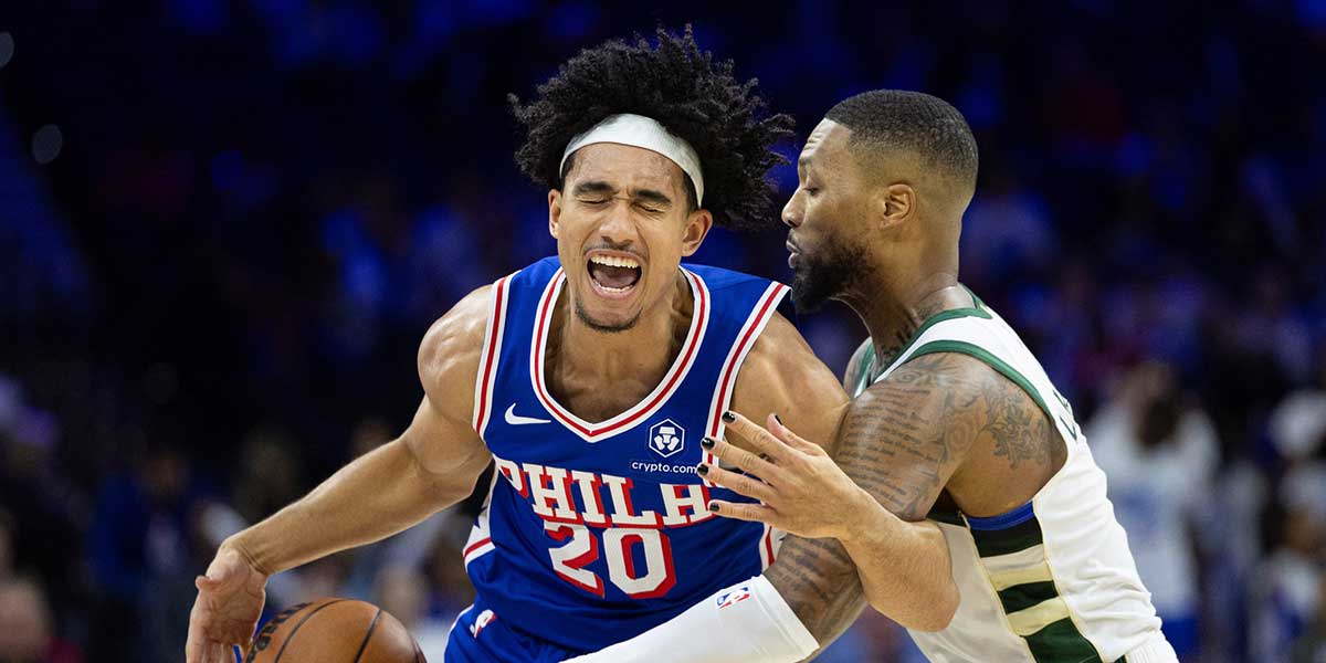 Philadelphia 76ers guard Jared McCain (20) reacts as he is fouled while driving against Milwaukee Bucks guard Damian Lillard (0) during the fourth quarter at Wells Fargo Center. 