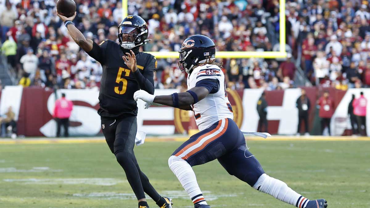 Washington Commanders quarterback Jayden Daniels (5) passes the ball as Chicago Bears defensive end Darrell Taylor (52) chases during the first quarter at Northwest Stadium.