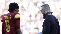 Washington Commanders quarterback Jayden Daniels (5) talks with Commanders offensive coordinator Kliff Kingsbury (R) during a timeout Dallas Cowboys during the second quarter at Northwest Stadium.