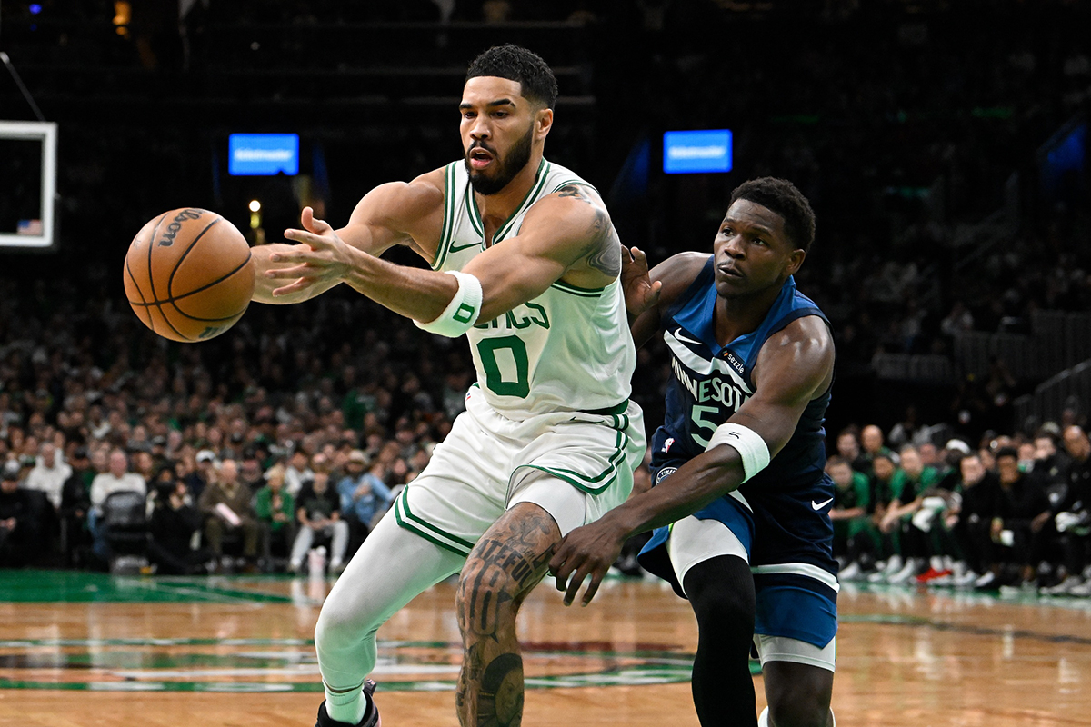 Boston Celtics forward Jayson Tatum (0) grabs for the ball while covered by Minnesota Timberwolves guard Anthony Edwards (5) during the first half at TD Garden.