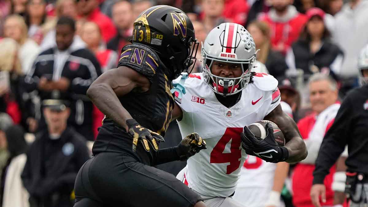 Ohio State Buckeyes wide receiver Jeremiah Smith (4) runs around Northwestern Wildcats defensive back Josh Fussell (13) during the NCAA football game at Wrigley Field