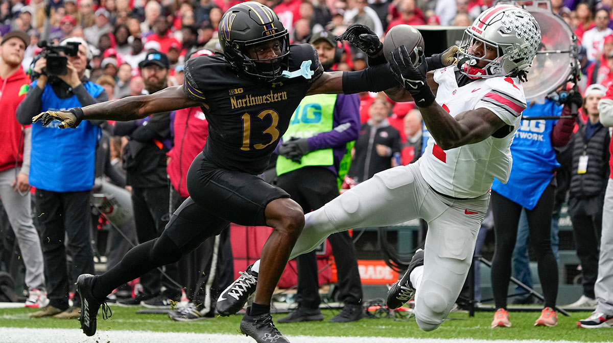 Ohio State Buckeyes wide receiver Jeremiah Smith (4) attempts a one handed catch in front of Northwestern Wildcats defensive back Josh Fussell (13) during the first half of the NCAA football game at Wrigley Field in Chicago.