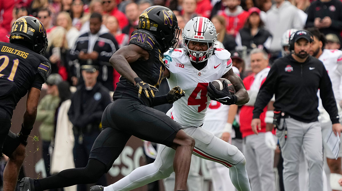 Ohio State Buckeyes wide receiver Jeremiah Smith (4) runs around Northwestern Wildcats defensive back Josh Fussell (13) during the NCAA football game at Wrigley Field in Chicago.