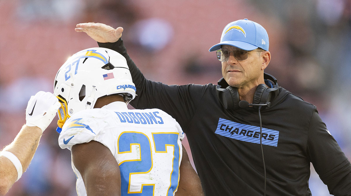 Los Angeles Chargers head coach Jim Harbaugh congratulates running back J.K. Dobbins (27) on his touchdown against the Cleveland Browns during the fourth quarter at Huntington Bank Field.
