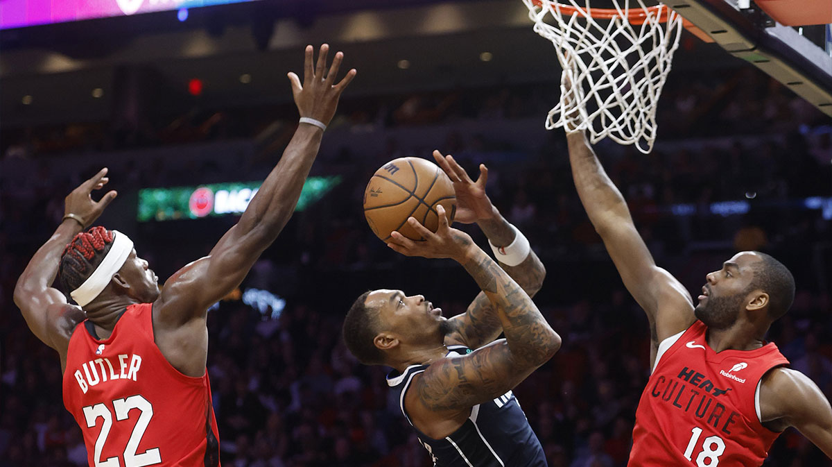 Miami Heat forward Jimmy Butler (22) and guard Alec Burks (18) defend Dallas Mavericks forward P.J. Washington (25) during the second half at Kaseya Center.