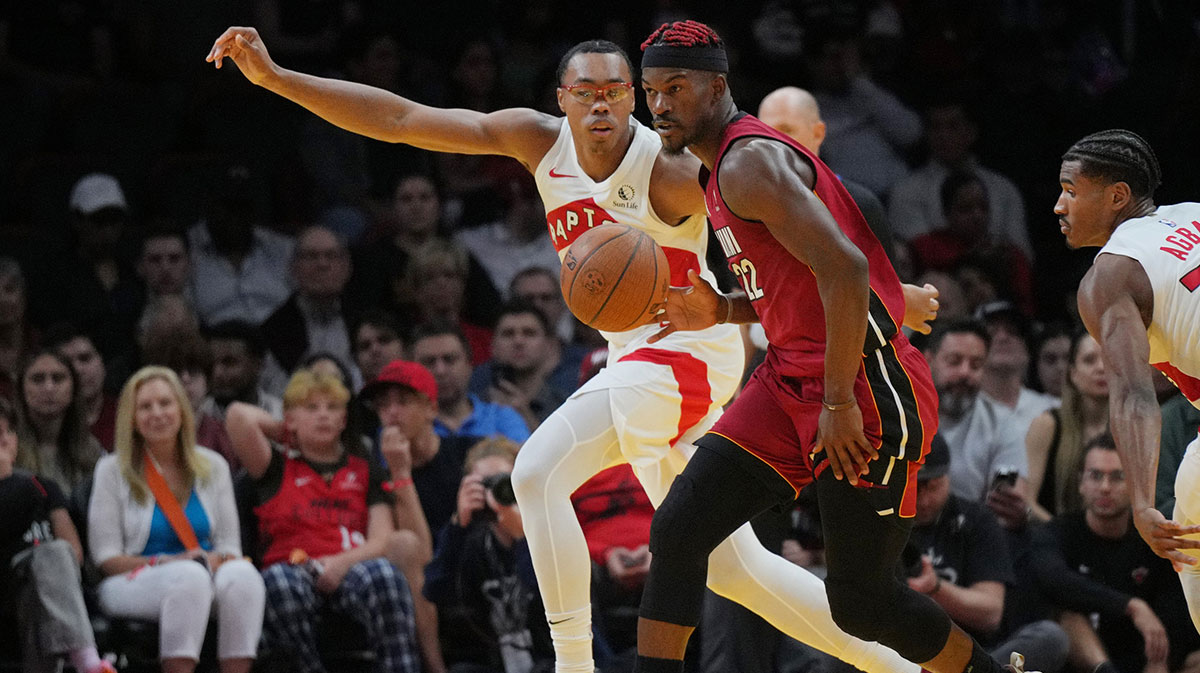 Miami Heat forward Jimmy Butler (22) looks for an open teammate as Toronto Raptors forward Scottie Barnes (4) defends during the first half in an NBA Cup game at Kaseya Center. 