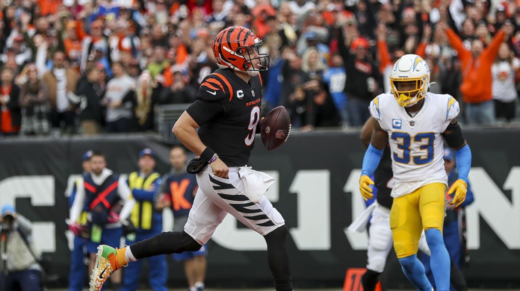 Cincinnati Bengals quarterback Joe Burrow (9) runs the ball in for a touchdown against Los Angeles Chargers safety Derwin James Jr. (33) in the first half at Paul Brown Stadium.