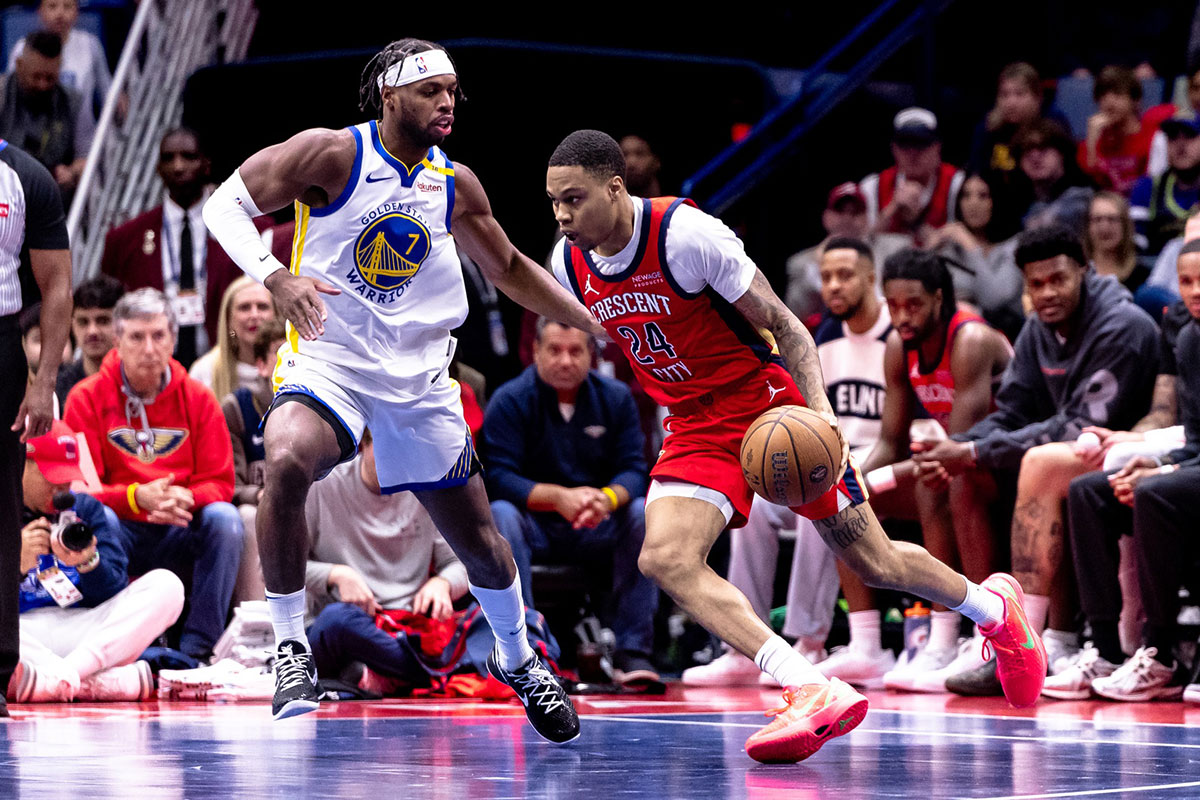 New Orleans Pelicans guard Jordan Hawkins (24) dribbles against Golden State Warriors guard Buddy Hield (7) during second half at Smoothie King Center.