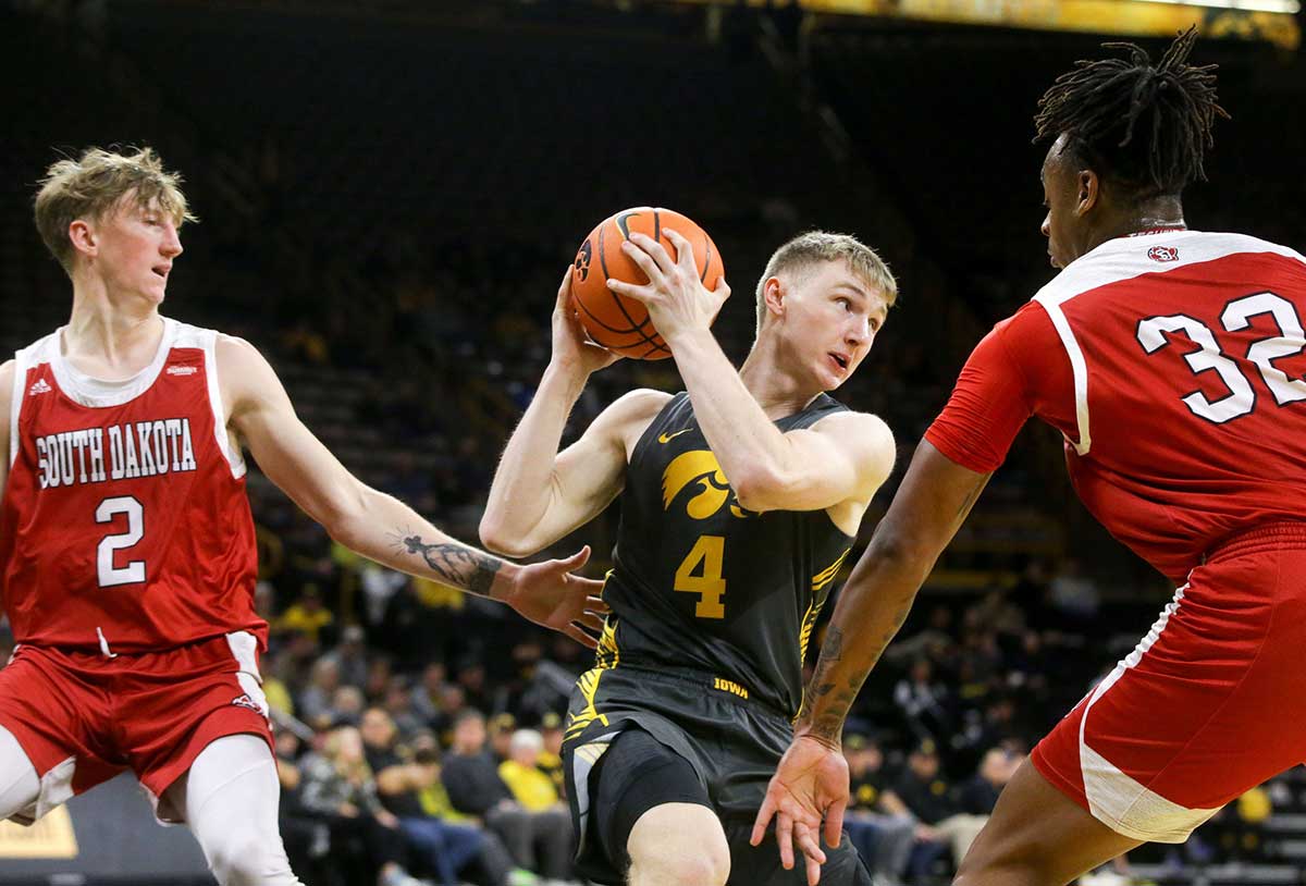 Iowa guard Josh Dix (4) secures the ball against South Dakota guard Shey Eberwein (2) and South Dakota forward Ashton Smith (32) Tuesday, Nov. 12, 2024 at Carver-Hawkeye Arena in Iowa City, Iowa.