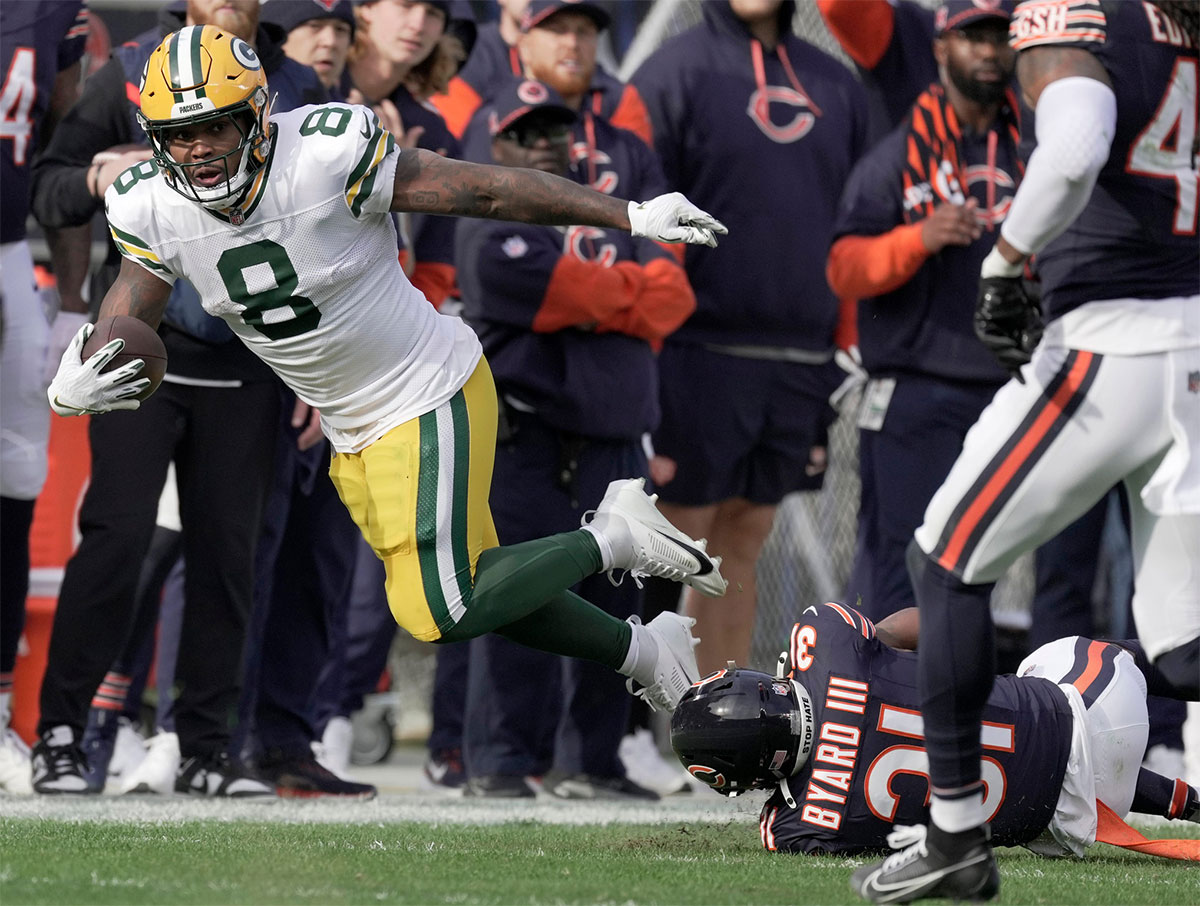 Green Bay Packers running back Josh Jacobs (8) is tripped up short of a first down by Chicago Bears safety Kevin Byard III (31) after a reception during the first quarter of their game Sunday, November 17, 2024 at Soldier Field in Chicago, Illinois.