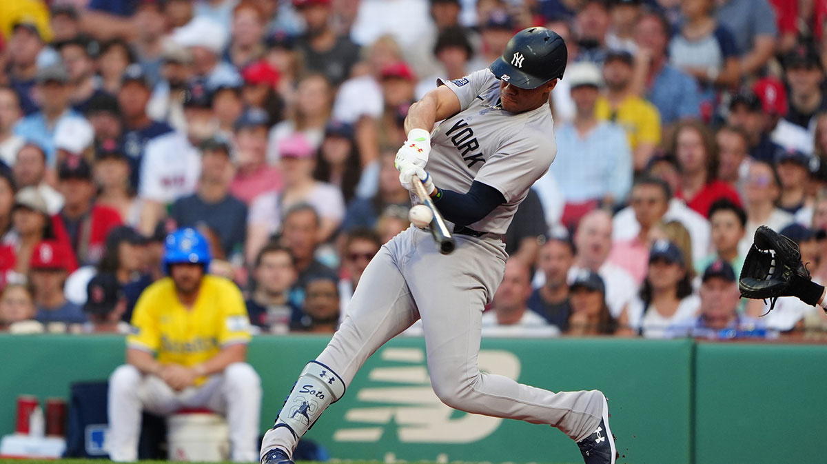 New York Yankees left fielder Juan Soto (22) hits a two-run home run against the Boston Red Sox during the first inning at Fenway Park.