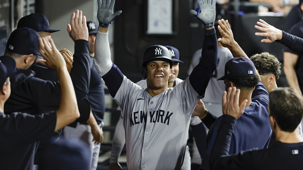 New York Yankees outfielder Juan Soto (22) celebrates with teammates in the dugout after hitting a solo home run against the Chicago White Sox during the fifth inning at Guaranteed Rate Field.