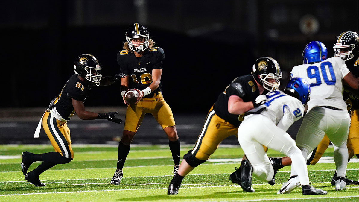 Carrollton Trojans quarterback Julian Lewis (10) hands-off against the Westlake Lions during the first half at Grisham Stadium. The 15-year-old Carrollton High student has already committed to playing for the University of Southern California Trojans and has been considered one of the top high school quarterback prospects.
