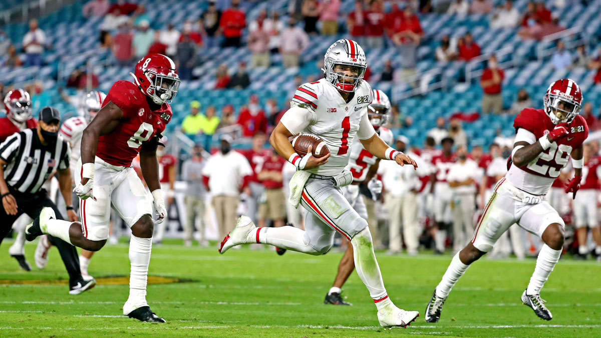 Ohio State Buckeyes quarterback Justin Fields (1) runs the ball against Alabama Crimson Tide linebacker Christian Harris (8) and defensive back DeMarcco Hellams (29) during the third quarter in the 2021 College Football Playoff National Championship Game.