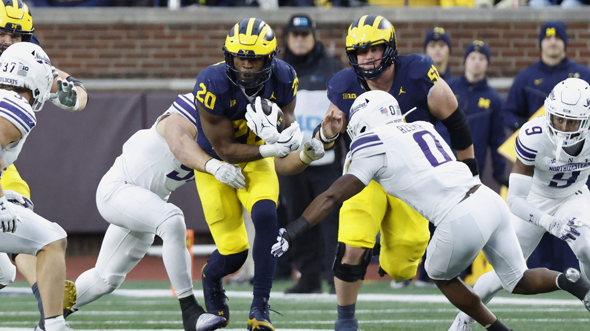 Michigan Wolverines running back Kalel Mullings (20) is tackled by Northwestern Wildcats defensive back Devin Turner (8) in the first half at Michigan Stadium.