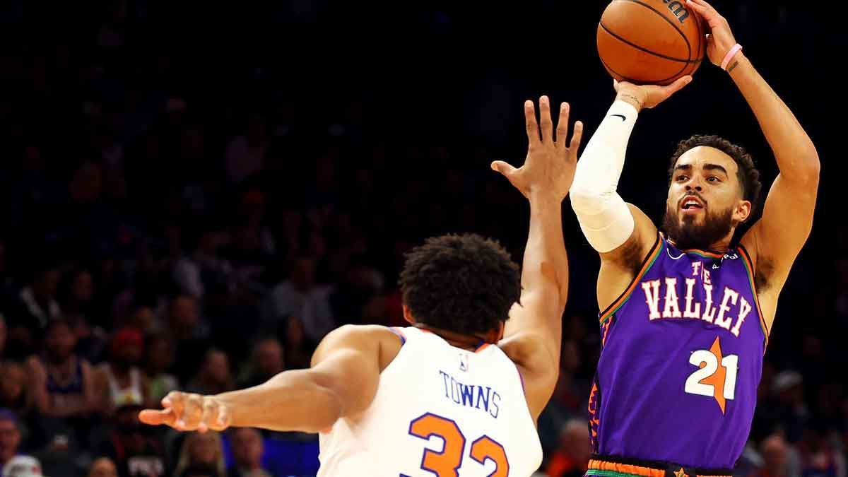Phoenix Suns guard Tyus Jones (21) shoots the ball over New York Knicks center Karl-Anthony Towns (32) during the first quarter at Footprint Center.