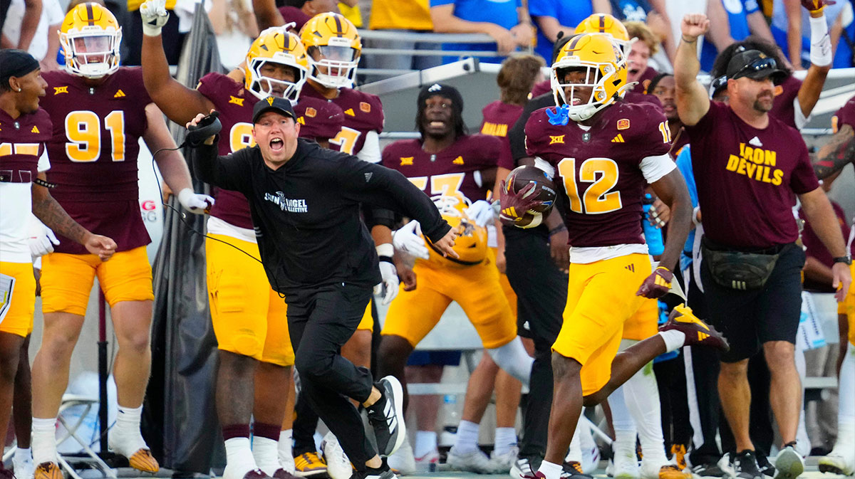Arizona State head coach Kenny Dillingham runs with Arizona State defensive back Javan Robinson (12) as he returns an interception against BYU during the second half at Mountain America Stadium in Tempe on Nov. 23, 2024.