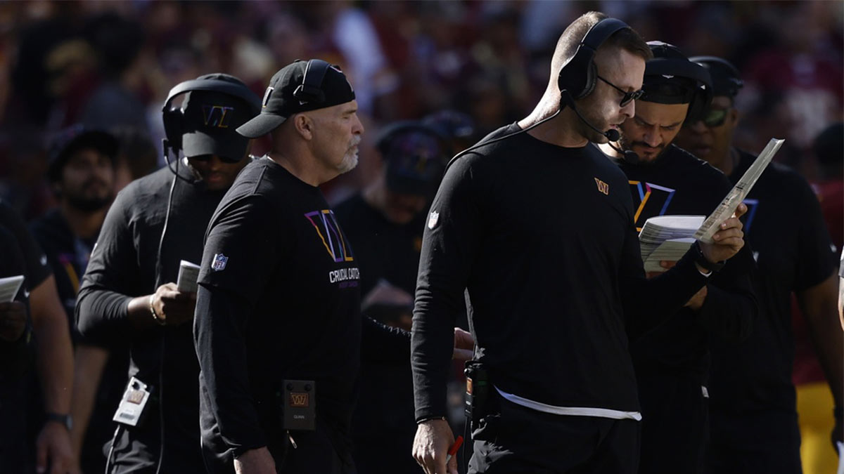 Washington Commanders offensive coordinator Cliff Kingsbury (R) looks at his play sheet during a timeout against the Cleveland Browns during the third quarter at NorthWest Stadium.