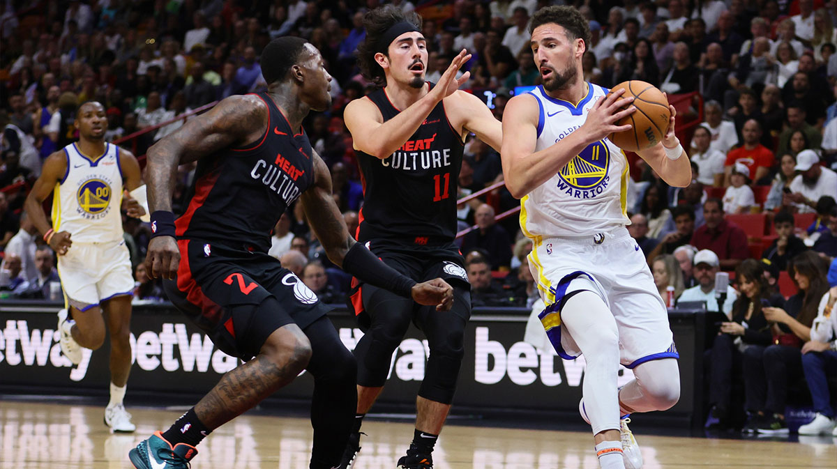 Golden State Warriors guard Klay Thompson (11) drives to the basket past Miami Heat guard Terry Rozier (2) and guard Jaime Jaquez Jr. (11) during the first quarter at Kaseya Center.