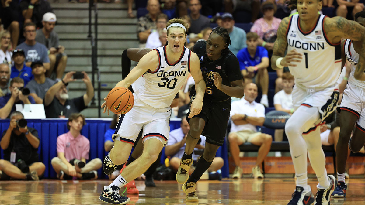 UConn Huskies forward Liam McNeeley (30) gets chased down by Memphis Tigers guard Baraka Okojie (6) in overtime during an NCAA college basketball game at Lahaina Civic Center.