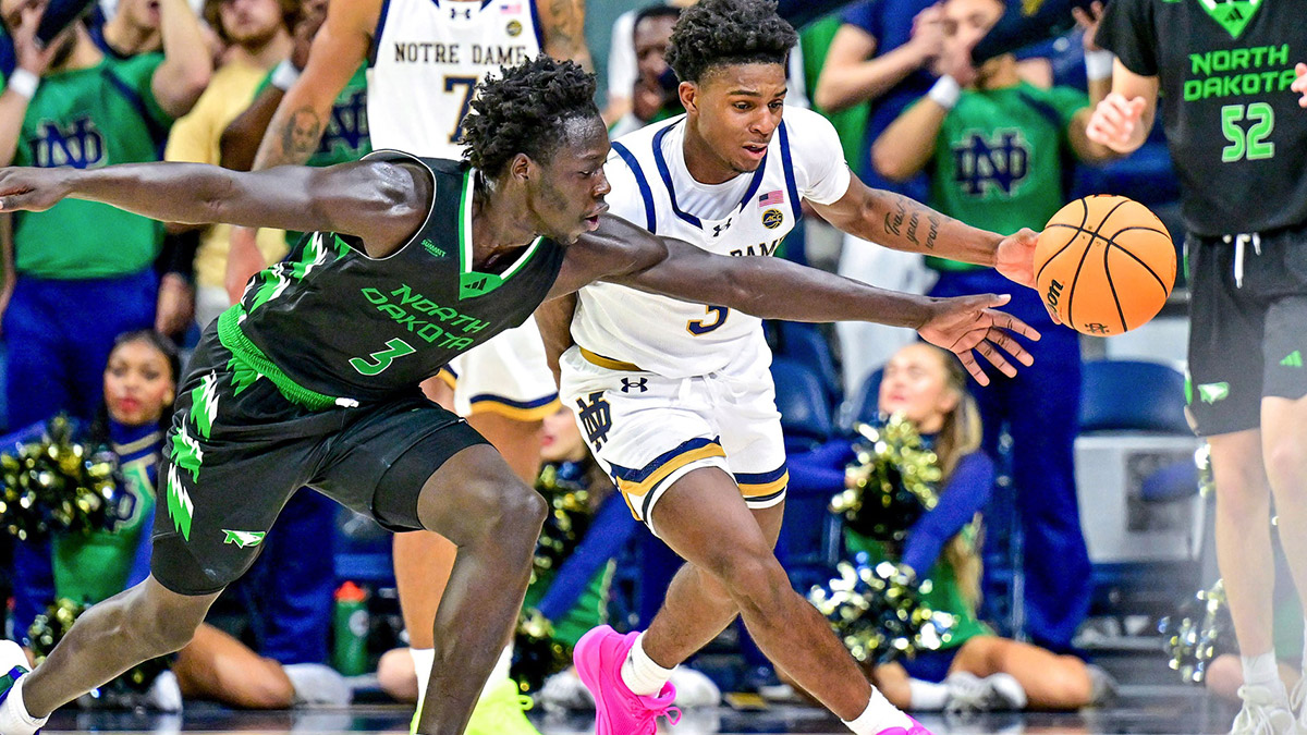 Notre Dame Fighting Irish guard Markus Burton (3) knocks the ball away from North Dakota Fighting Hawks guard Mier Panoam (3) in the second half at the Purcell Pavilion.