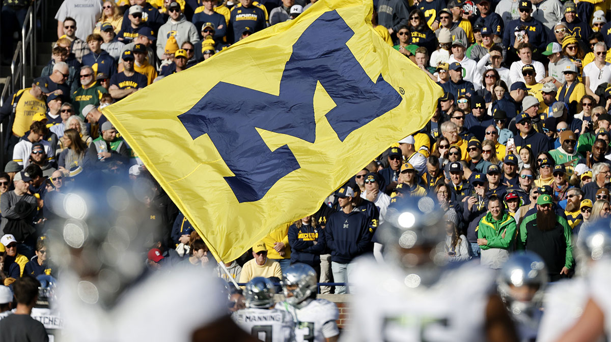 Michigan Wolverines cheerleader runs with a flag before the game against the Oregon Ducks at Michigan Stadium.