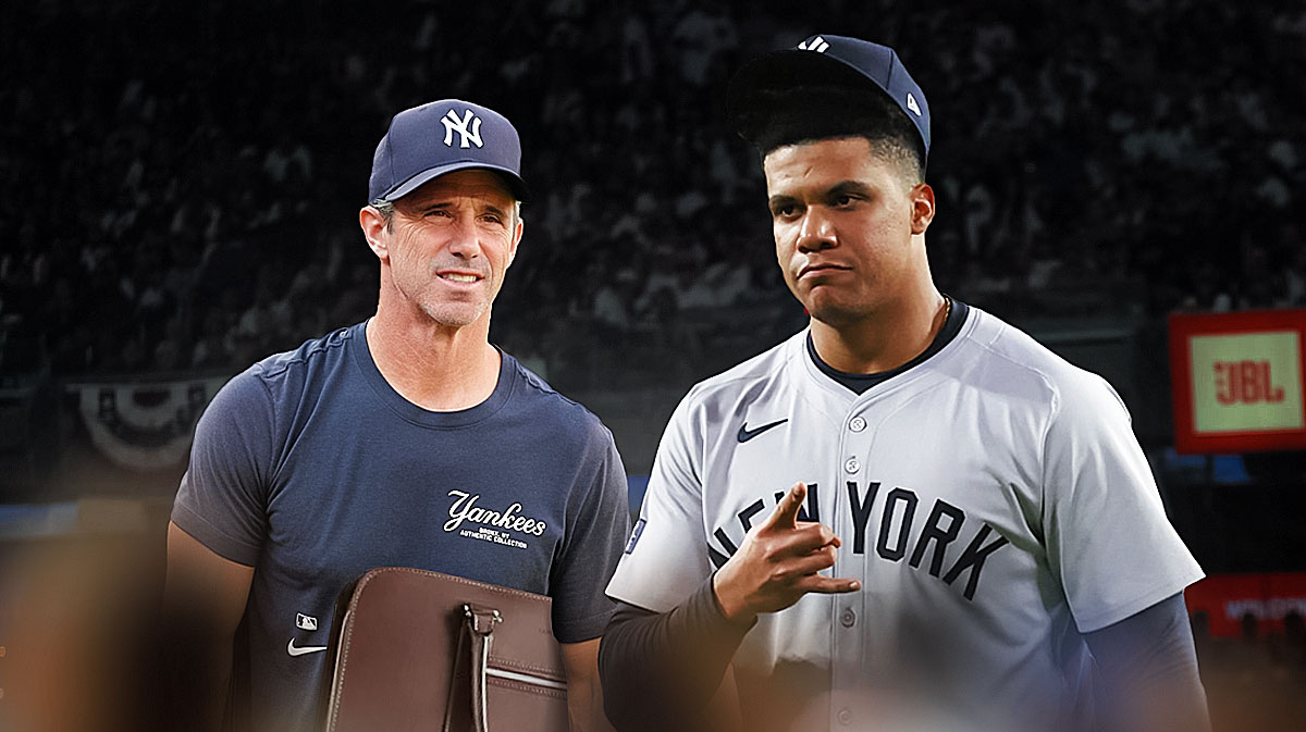 Brad Ausmus (Yankees bench coach) dressed for vacation, holding suitcases. Juan Soto (Yankees) in uniform next to him