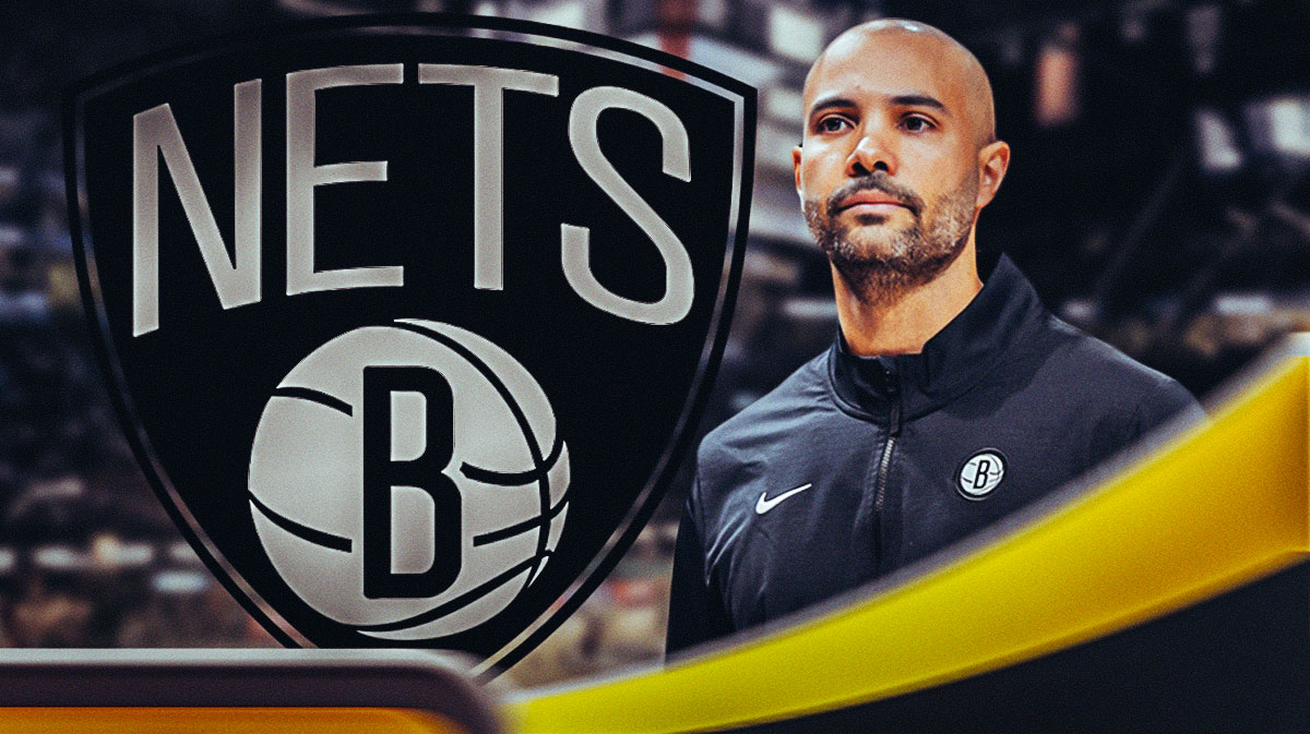 Jordi Fernandez looking upset next to a Nets logo