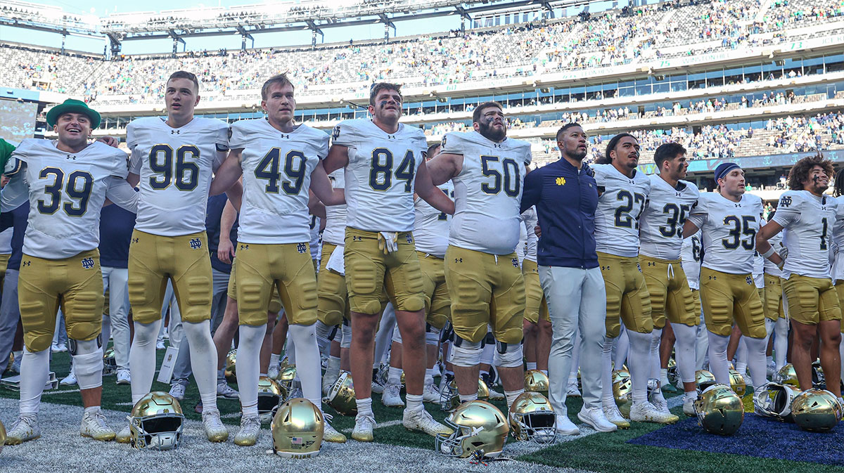 Notre Dame Fighting Irish head coach Marcus Freeman stands with his team for their alma mater after their game against the Navy Midshipmen at MetLife Stadium