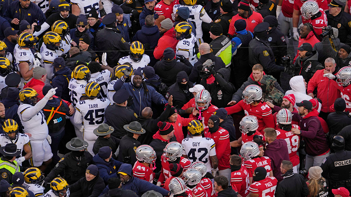 Players scrum at midfield following Saturday’s NCAA Division I football game between the Ohio State Buckeyes and the Michigan Wolverines.