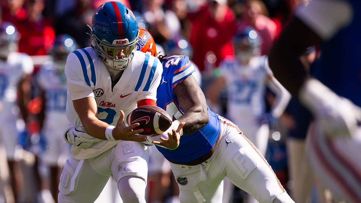 Mississippi quarterback Jaxson Dart (2) bobbles the ball as Florida defender Kamran James (24) tackles him during the first half at Ben Hill Griffin Stadium in Gainesville, Fla., on Saturday,