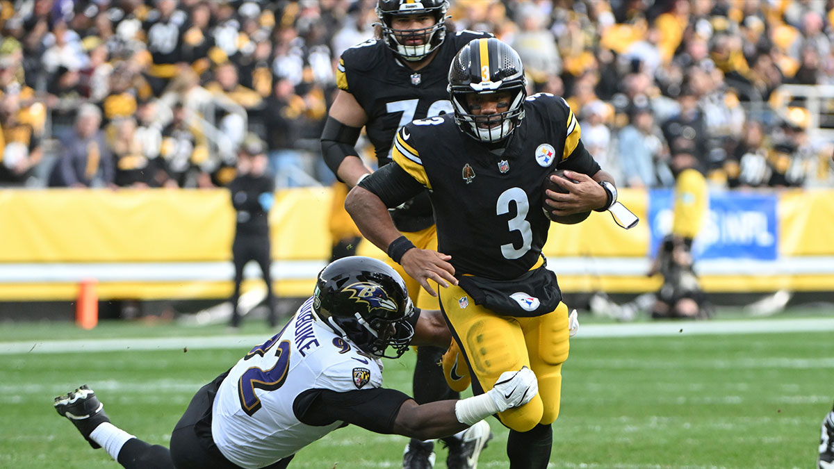 Pittsburgh Steelers quarterback Russell Wilson (3) runs away from Baltimore Ravens defensive tackle Nnamdi Madubuike (92) during the second quarter at Acrisure Stadium.