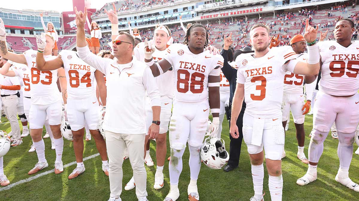Texas Longhorns head coach Steve Sarkisian, edge Barryn Sorrell (88) and quarterback Quinn Ewers (3) celebrate after the game against the Arkansas Razorbacks at Donald W. Reynolds Razorback Stadium. Texas won 20-10